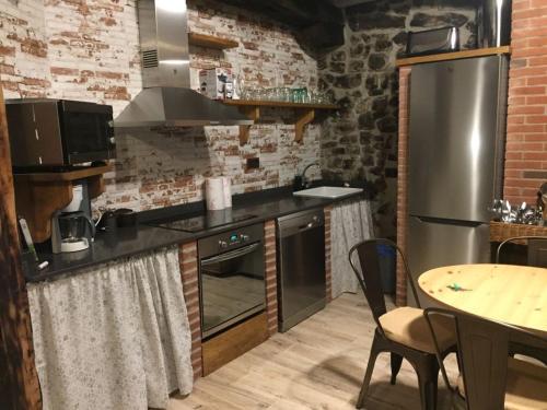 a kitchen with a stainless steel refrigerator and a table at LA RAMA DEL CASTOR in Espinama