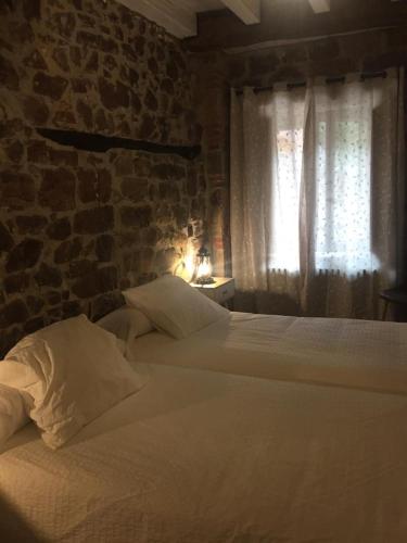 a bedroom with two beds and a brick wall at LA RAMA DEL CASTOR in Espinama