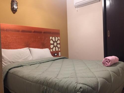 a bedroom with a bed with a pink towel on it at H100 Pyramids View in Giza