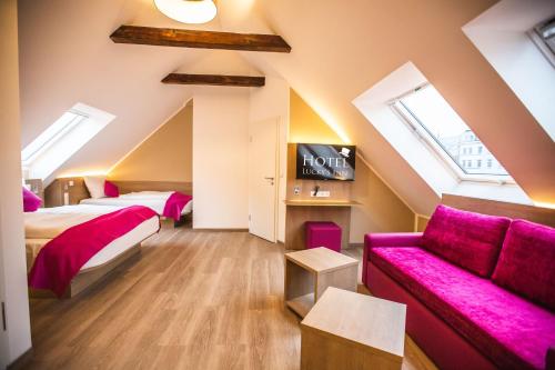 a attic bedroom with two beds and a couch at Hotel Luckys Inn in Hamburg