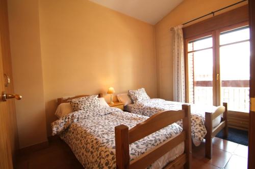1 dormitorio con 2 camas y ventana en Borda Pascol, Atico Duplex en Tarter Zona Grandvalira en Canillo
