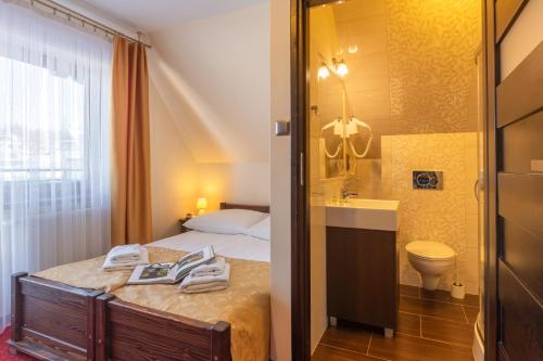 a bedroom with a bed and a sink and a toilet at Willa Skalny Potok 605-077-100 in Zakopane