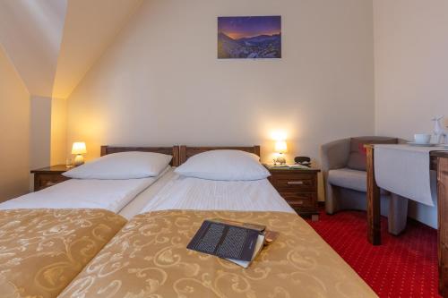 a bedroom with two beds with a book on the bed at Willa Skalny Potok 605-077-100 in Zakopane