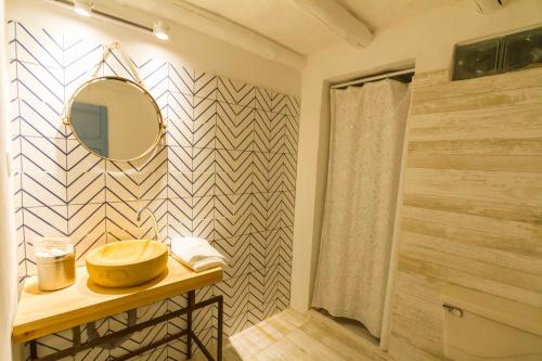y baño con lavabo, espejo y ducha. en Casa Provenzal, en Villa de Leyva