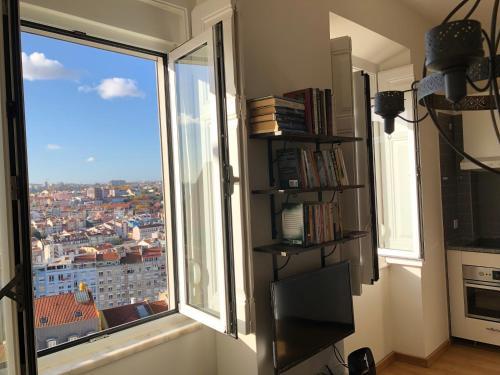 a room with a window with a view of a city at The Hilltop Nest in Lisbon