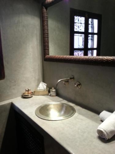 une salle de bains avec un lavabo et un miroir dans l'établissement Riad AZZA, à Marrakech