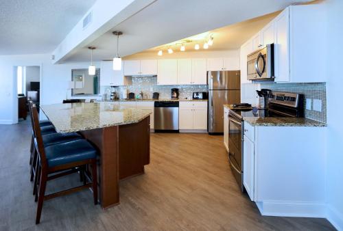 a kitchen with white cabinets and a large island at Atlantic Terrace in Daytona Beach Shores