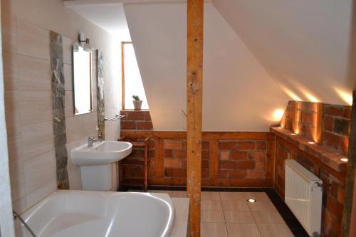 y baño con lavabo, bañera y aseo. en Pensjonat Mimoza, en Świeradów-Zdrój