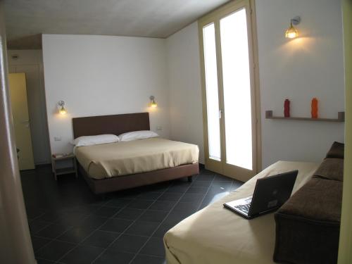 a hotel room with two beds and a laptop computer at 6 Porte Guesthouse in Mantova