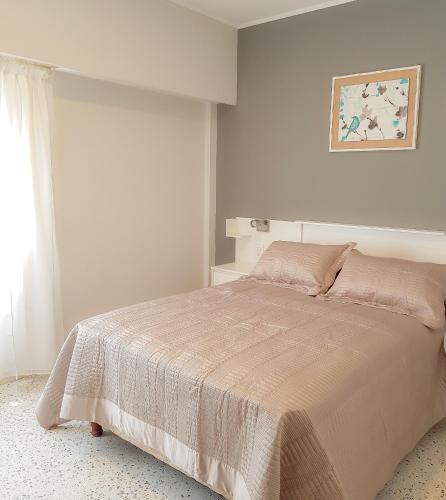 a white bedroom with a bed and a window at Mares Apart Hotel in Mar de Ajó