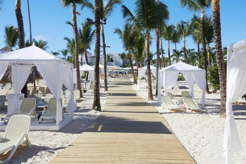 a wedding aisle on the beach with chairs and palm trees at Bahia Principe Luxury Ambar - Adults Only All Inclusive in Punta Cana