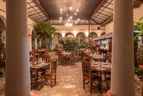 a restaurant with tables and chairs and a chandelier at Plaza Magnolias in San Cristóbal de Las Casas