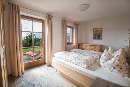 een slaapkamer met een bed en een groot raam bij Apartments Pitschlmann in Fiè