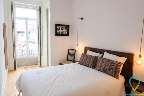 a bedroom with a bed and a large window at Simply Porto in Porto