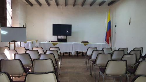 a room with a table and chairs and a tv at Casa Hotel Guaracú in Santa Fe de Antioquia