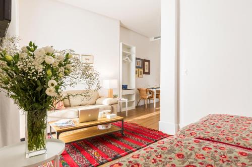 ein Wohnzimmer mit einer Blumenvase auf dem Tisch in der Unterkunft Sevilla Home Center Suites in Sevilla