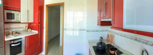 a kitchen with red and white cabinets and a sink at Apartamento ARENA en Santa Cruz de la Palma in Santa Cruz de la Palma