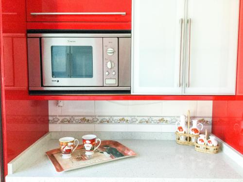 a kitchen with a microwave and cups on the counter at Apartamento ARENA en Santa Cruz de la Palma in Santa Cruz de la Palma