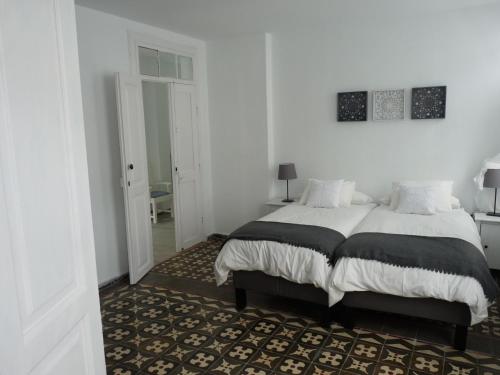 a white bedroom with a bed and a rug at MULAGUA in Agulo