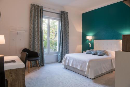 um quarto com uma cama branca e uma janela em Hôtel Radio - Teritoria em Chamalières