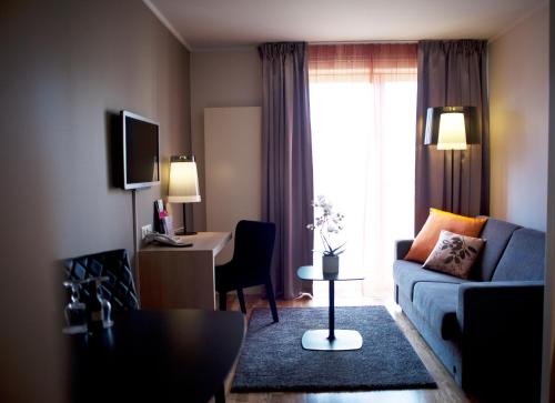 a living room with a couch and a table at Comfort Hotel Park in Trondheim