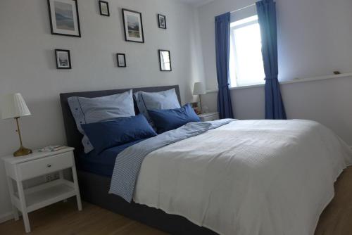 Un dormitorio con una cama con almohadas azules y una ventana en Ferienscheune Juhlsgaard en Husby