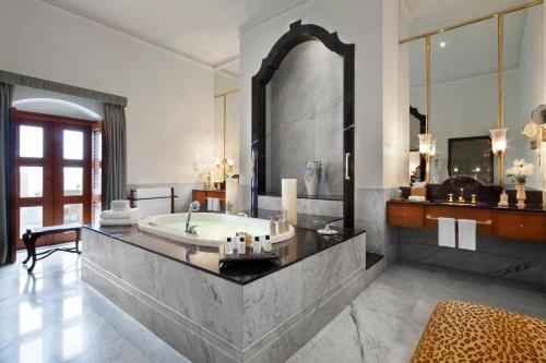 a bathroom with a tub and a large mirror at Taj Falaknuma Palace in Hyderabad