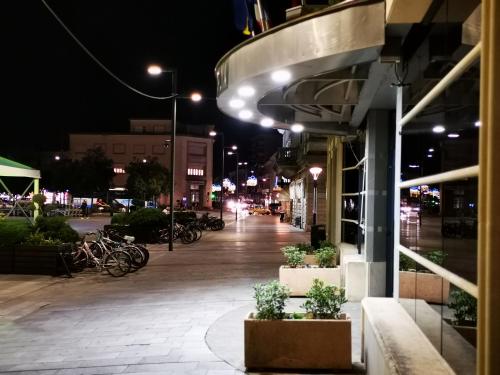 an empty street at night with bikes parked outside of a building at HR Hotel in Monfalcone