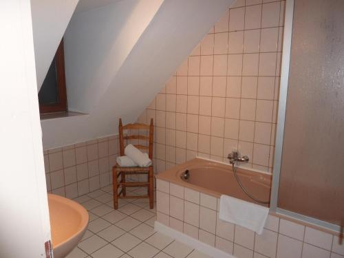 a bathroom with a bath tub and a sink at Gîte Le Riesling in Bergheim