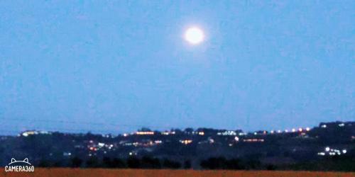a moon in the sky over a city at night at เฟรนด์แคมป์ in Khao Kho
