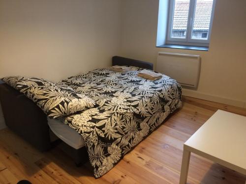 - un petit lit dans une chambre avec une table dans l'établissement Appartement centre St Genest Malifaux, à Saint-Genest-Malifaux