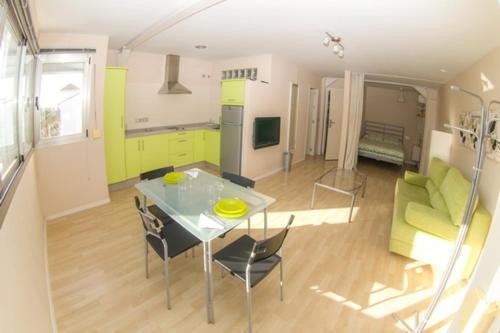 a kitchen and living room with a table and chairs at Apartamentos Loft Tarifa in Tarifa
