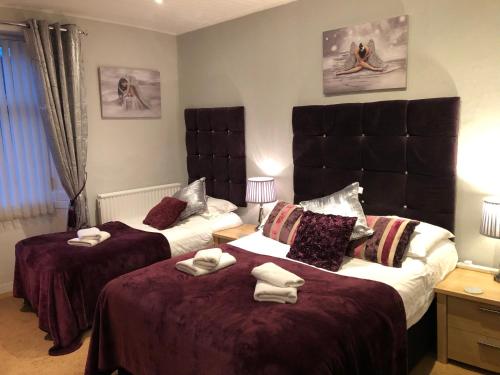 a bedroom with two beds with towels on them at The Georgian Guesthouse in Alnwick