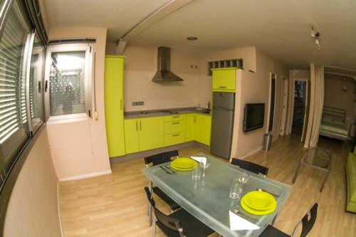 a kitchen with yellow cabinets and a table with yellow plates on it at Apartamentos Loft Tarifa in Tarifa