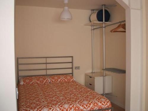 a bedroom with a bed with a orange bedspread at Apartamentos Loft Tarifa in Tarifa