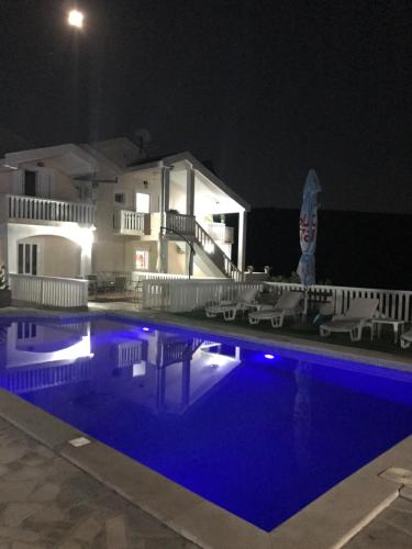 a swimming pool in front of a house at night at Apartments Vila Lazarevic in Tivat