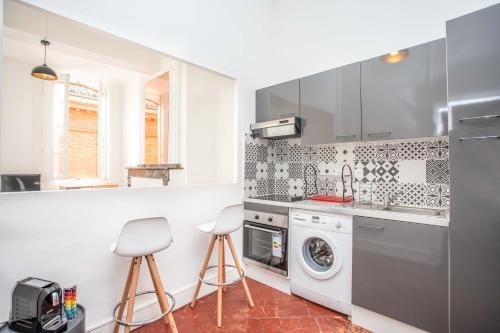 uma cozinha com uma máquina de lavar roupa e 2 bancos em Appartement 6 - Standing et Lumineux - Carmes, Toulouse em Toulouse
