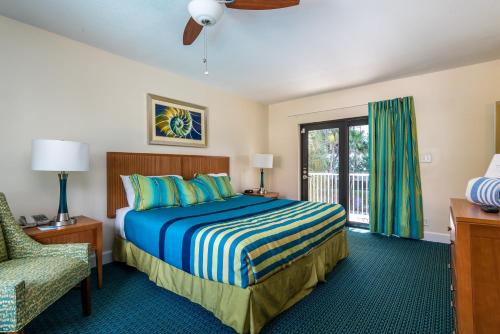 a bedroom with a bed and a chair and a window at La Costa Beach Club in Pompano Beach
