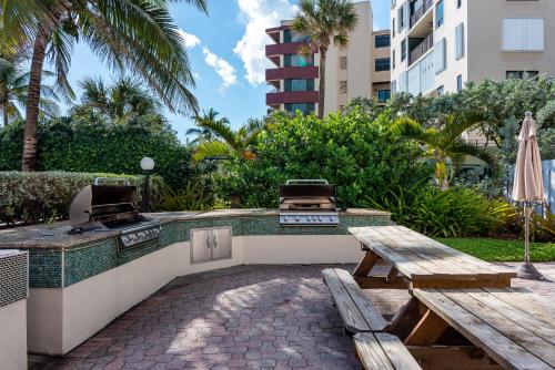 a patio with a picnic table and a grill at La Costa Beach Club in Pompano Beach
