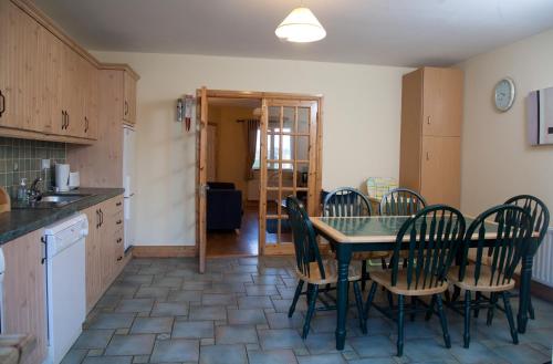 
a kitchen with a table and chairs and a refrigerator at Ceol na Mara Holiday Homes - Cois Tra & Cor na dTonn in Enniscrone

