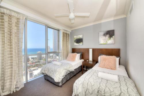 1 Schlafzimmer mit 2 Betten und einem großen Fenster in der Unterkunft Deluxe Chevron Renaissance in Gold Coast