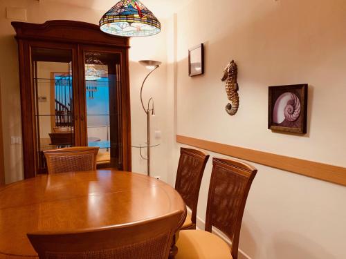 a dining room with a wooden table and chairs at Saval Spa Aqquaria Family Complex in Salou