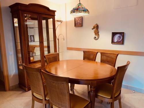a dining room with a wooden table and chairs at Saval Spa Aqquaria Family Complex in Salou