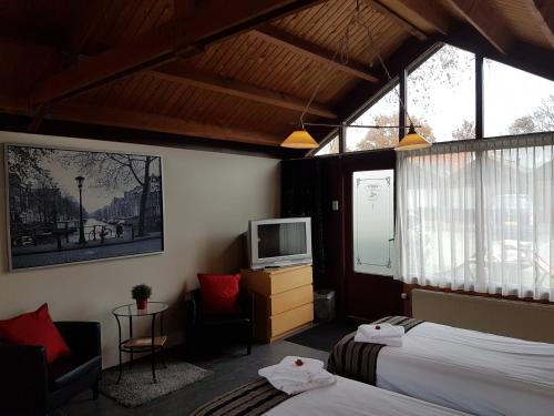 a hotel room with two beds and a television at Motel Oostvoorne in Oostvoorne