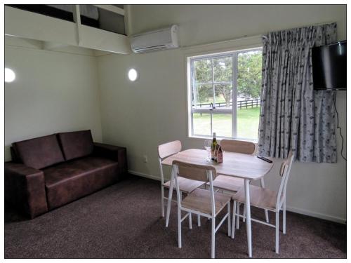 a living room with a table and a couch at Grandeur Thermal Spa Resort in Taupo