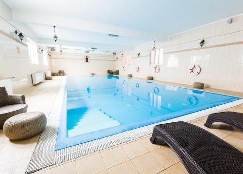 a large swimming pool in a room at Prawdzic Family Resort & Wellness in Gdańsk