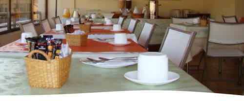 een tafel met stoelen en een tafel met borden en drankjes erop bij Alessandria Apart - El Bosque Norte in Santiago