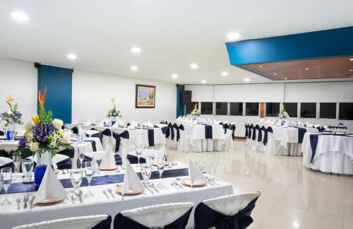 a banquet hall with white tables and chairs at Hotel Don Saul in Pasto