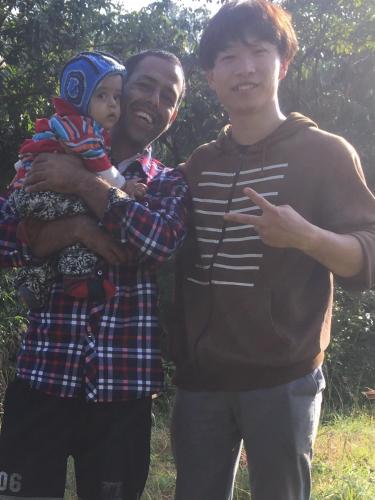 two men standing next to each other holding a child at Mount Fuji Homestay in Deorāli