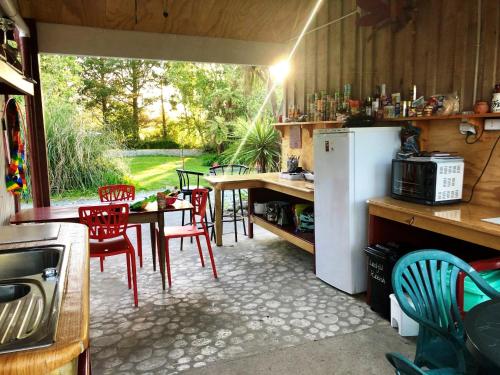 a kitchen with a table and chairs and a refrigerator at Greenstone Retreat in Kumara